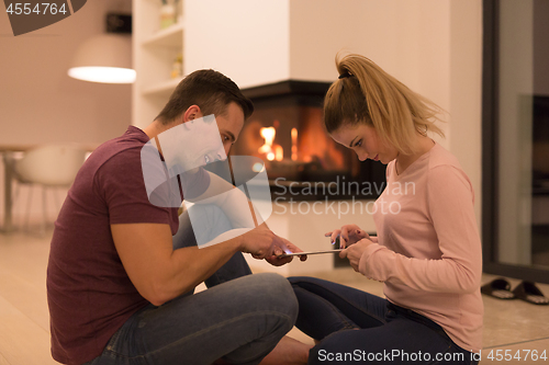 Image of Young Couple using digital tablet on cold winter night