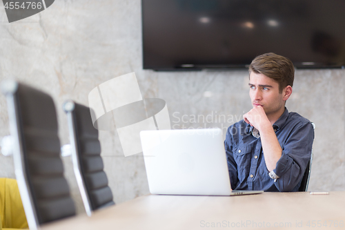 Image of businessman working using a laptop in startup office