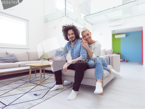 Image of Young couple on the sofa watching television