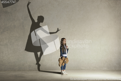 Image of Baby girl dreaming a dancing ballet on the stage. Childhood concept.