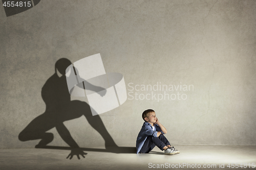 Image of The little boy dreaming about hero figure