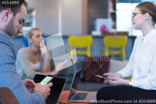 Image of Young casual businessman using smartphone