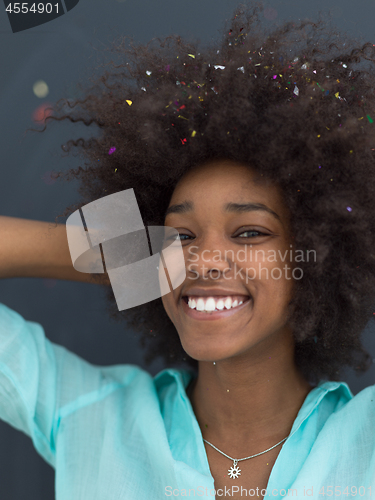 Image of black woman blowing confetti in the air