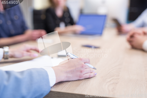 Image of businesswoman hand using pen