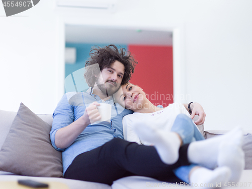 Image of Young couple on the sofa watching television