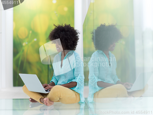 Image of black women using laptop computer on the floor