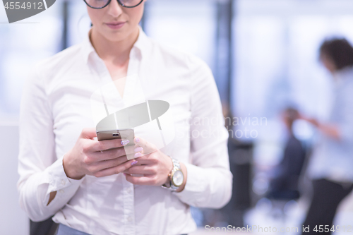 Image of Elegant Woman Using Mobile Phone in startup office building