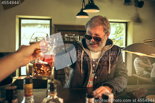 Image of The senior bearded male drinking beer in pub