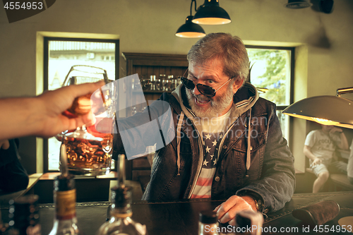 Image of The senior bearded male drinking beer in pub