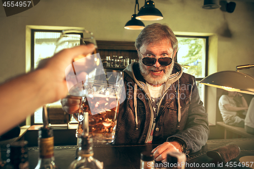 Image of The senior bearded male drinking beer in pub