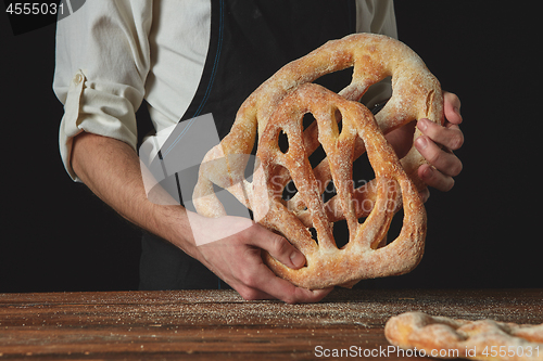 Image of Baker is holding fougas bread