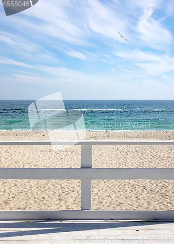 Image of View on a morning seascape with blue cloudy sky and sea from wooden deck.