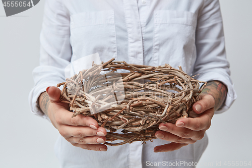 Image of Young girl holding a nest of branches