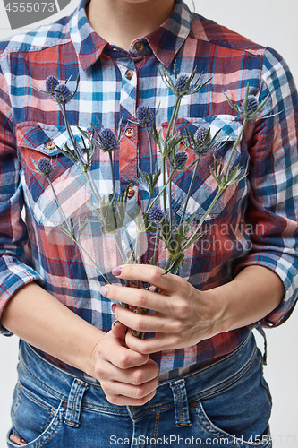 Image of girl holding blue flowers eryngium