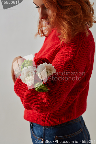 Image of A girl with a tattoo on her hands holding a bouquet of flowers on a gray.