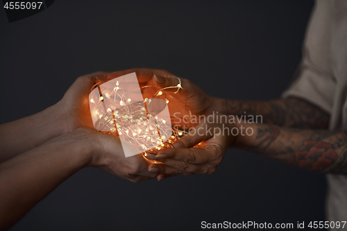 Image of Christmas lights garland in female hands