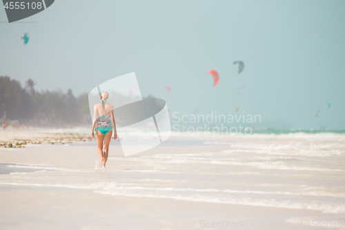 Image of Happy woman having fun, enjoying summer, walking joyfully on tropical beach, Zanzibar, Tanzania.