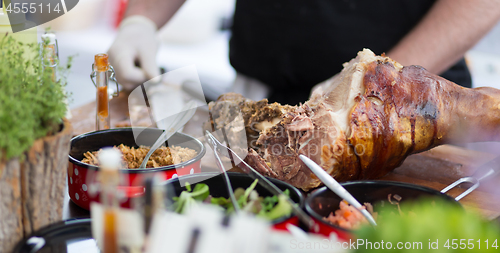 Image of Cheff serving traditional meat dish on street stall on street food festival, Ljubljana, Slovenia.