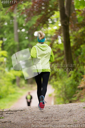 Image of Sporty young female runner in the forest.