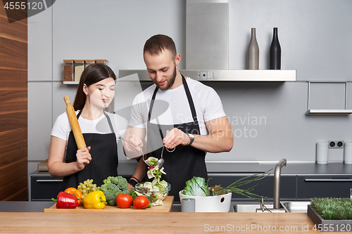 Image of Young family in the kitchen with vegetables