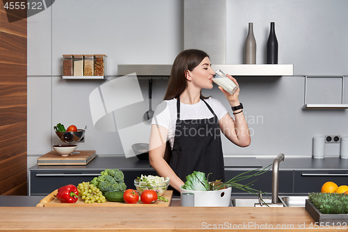 Image of woman in the kitchen drinking milk