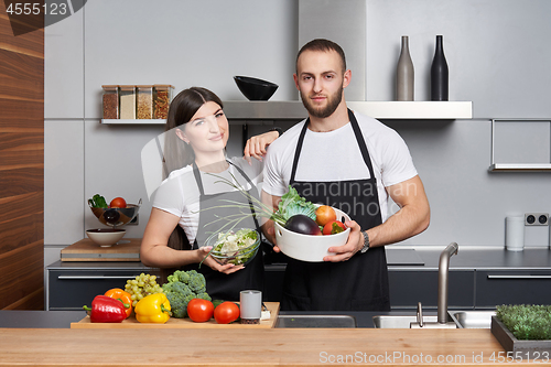 Image of Young family in the kitchen with vegetables