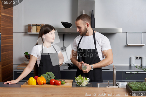 Image of Young family in the kitchen with vegetables