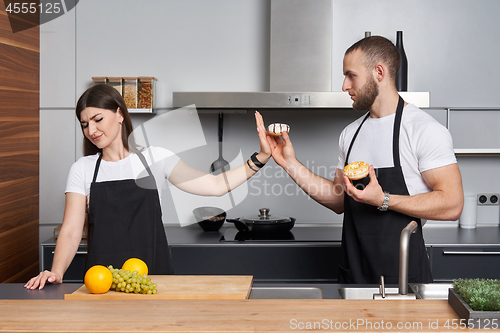 Image of Young family in the kitchen with vegetables