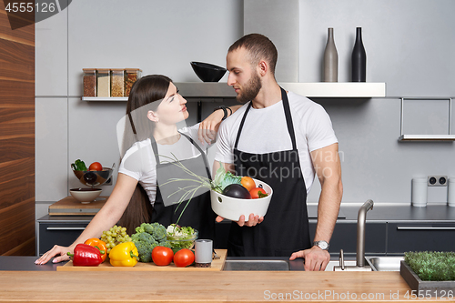 Image of Young family in the kitchen with vegetables