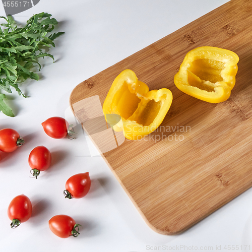 Image of Fresh pepper halves, cherry tomatoes and arugula on a gray background with copy space. Ingredients for salad. Flat lay