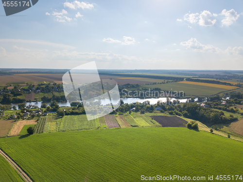 Image of Amazing countryscape with green fields, river, greenery and blue cloudy sky in a summer time.