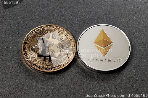 Image of Two coins bitcoin and ethereum on a dark background. Business concept