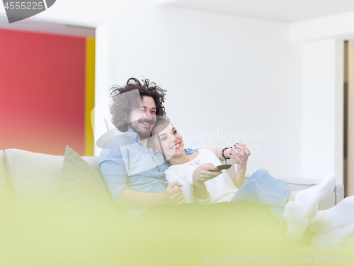 Image of Young couple on the sofa watching television