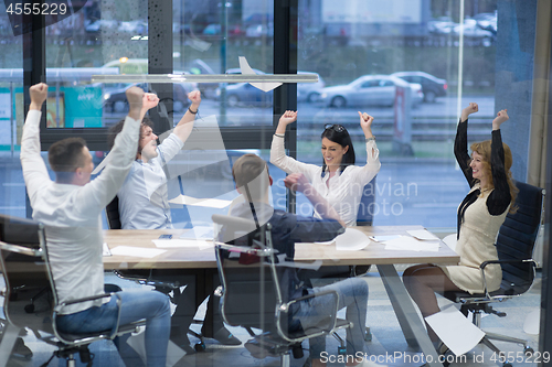 Image of startup Group of young business people throwing documents