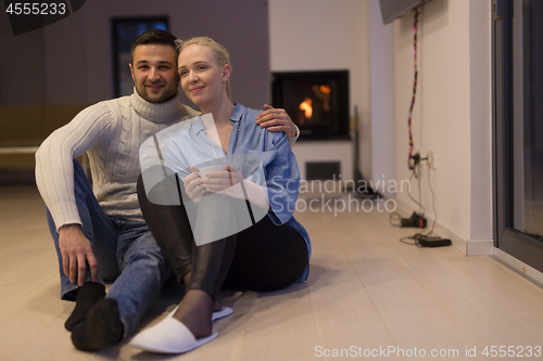 Image of happy couple in front of fireplace