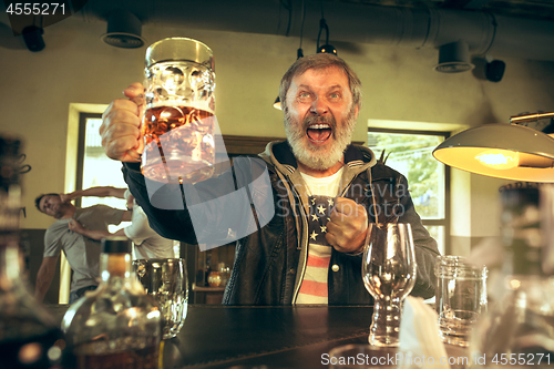 Image of The senior bearded male drinking beer in pub