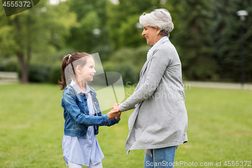 Image of grandmother and granddaughter playing at park