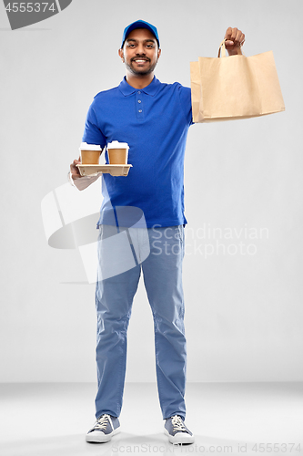 Image of happy indian delivery man with food and drinks