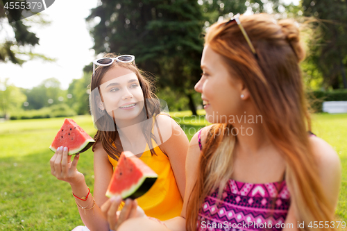 Image of teenage girls eating watermelon at picnic in park