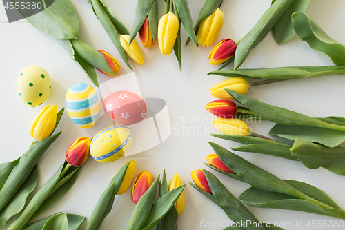 Image of close up of colored easter eggs and tulip flowers