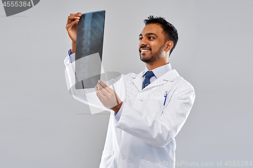 Image of smiling indian doctor looking at spine x-ray