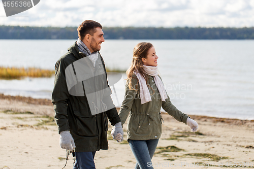 Image of couple walking along autumn beach