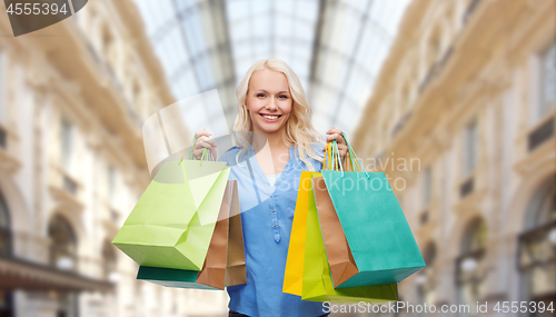 Image of woman with shopping bags over mall background