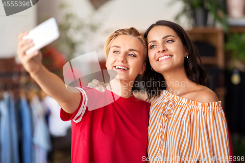 Image of female friends taking selfie at clothing store