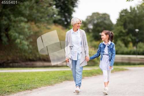 Image of grandmother and granddaughter walking at park