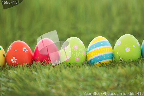 Image of row of colored easter eggs on artificial grass