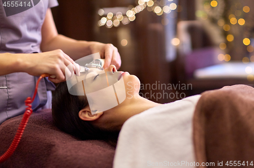 Image of woman having hydradermie facial treatment in spa