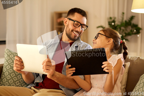 Image of father and daughter with tablet computers at home