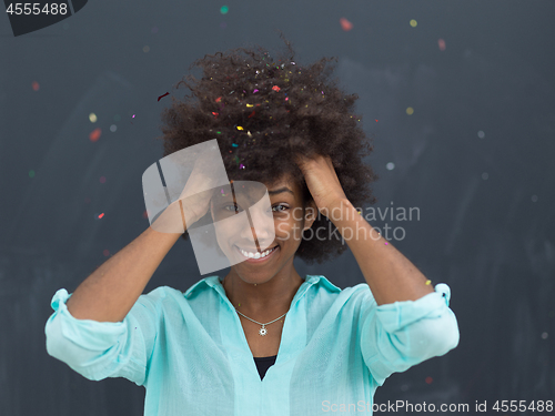 Image of black woman blowing confetti in the air