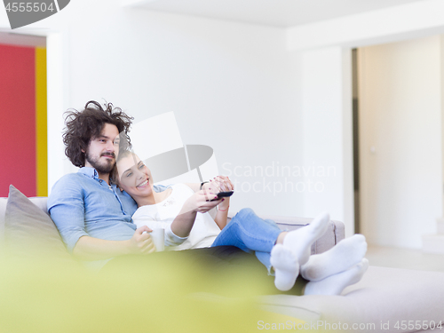 Image of Young couple on the sofa watching television